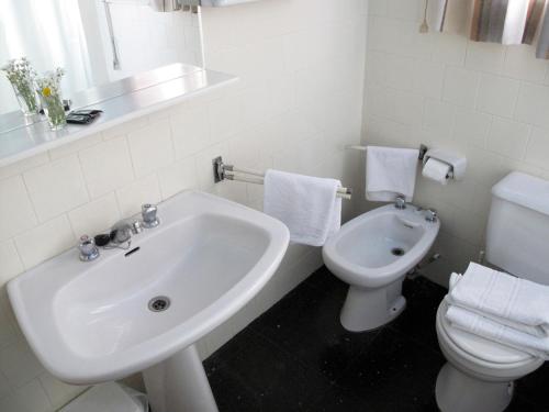 a white bathroom with a sink and a toilet at Hotel Martinez in Puigcerdà