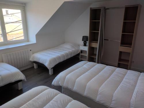 a room with three beds and a window at La Maison Boulonnaise in Boulogne-sur-Mer