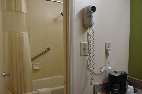 a phone is attached to the wall of a bathroom at Super 8 by Wyndham Tifton in Tifton