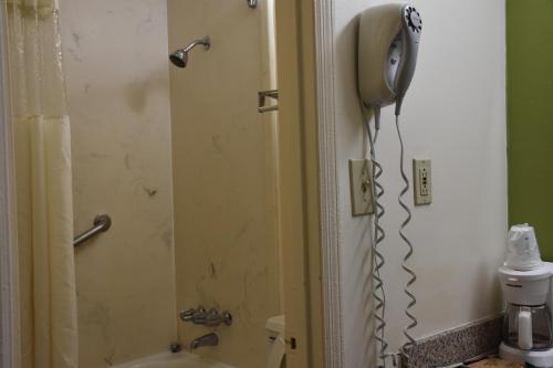 a bathroom with a shower with a phone on the wall at Super 8 by Wyndham Tifton in Tifton
