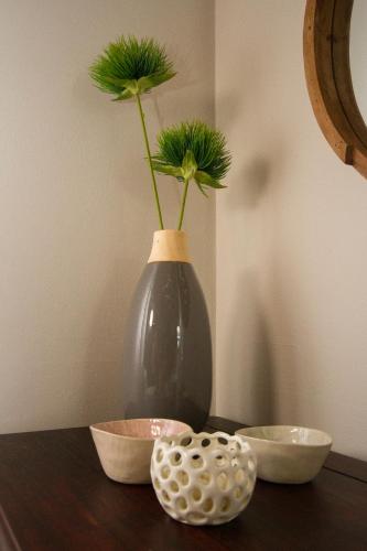 a vase with a flower in it sitting on a table at Little Rock Guesthouse in Jongensfontein