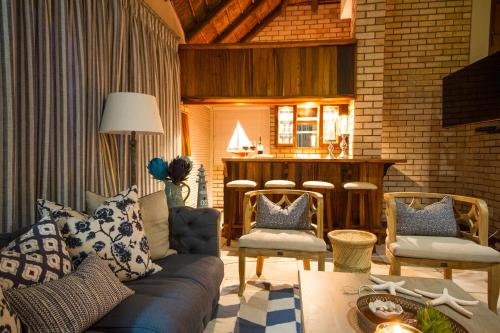 a living room with a blue couch and chairs at Little Rock Guesthouse in Jongensfontein