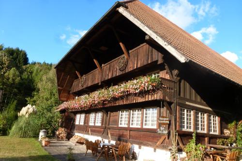 una gran casa de madera con flores en la fachada en Rommelehof, en Gutach