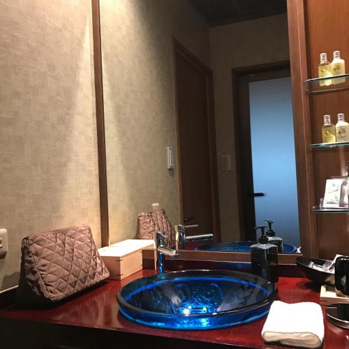 a bathroom with a blue sink and a mirror at Muromachi Yutone Kyokoyado in Kyoto