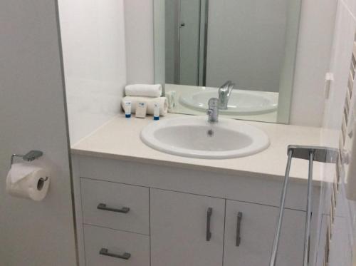 a bathroom with a white sink and a mirror at Kirrama 4 in Mission Beach