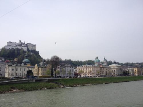 a city with a castle on a hill next to a river at Sarah's Altstadt Oase Salzburg in Salzburg