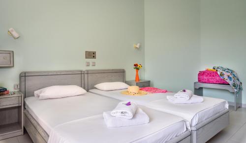 two beds in a room with towels on them at Louladakis Apartments in Kolymvari