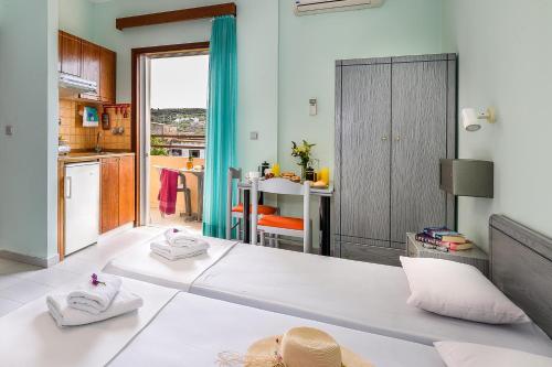 a living room with a large white bed and a kitchen at Louladakis Apartments in Kolymvari