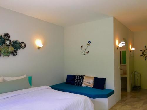 奈漢海灘的住宿－森斯雅鈕度假屋，一间卧室配有一张床和一个蓝色长椅