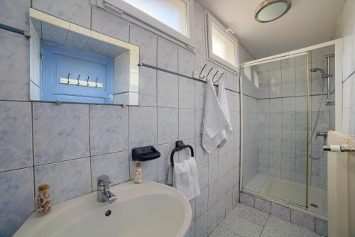 La salle de bains est pourvue d'un lavabo, d'une douche et d'une baignoire. dans l'établissement Appartement Xonrupt 6 personnes, à Xonrupt-Longemer