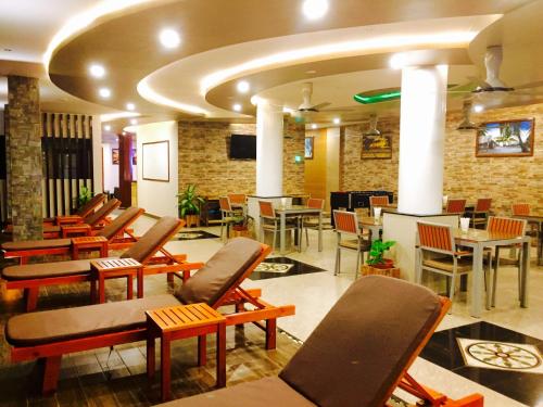 - un hall avec un bouquet de chaises et de tables dans l'établissement Triton Beach Hotel & Spa, à Maafushi