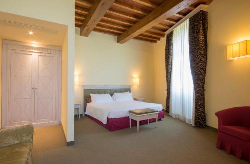 a hotel room with a bed and a red couch at LHP Hotel Certaldo in Certaldo
