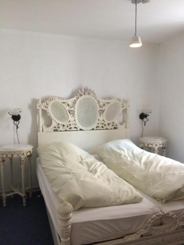a bedroom with a white bed with two tables at Motel Lido in Bredebro