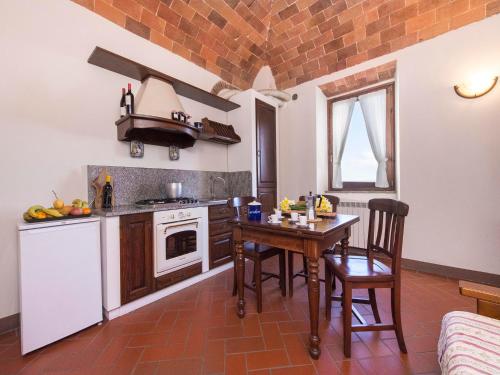 a kitchen with a table and a stove top oven at Country House il Ciliegio in Roccatederighi