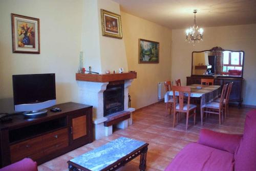 a living room with a couch and a table with a fireplace at Casa Rural Flor in Vadocondes