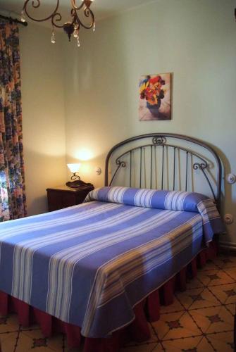 a bedroom with a bed with a blue and white blanket at Casa Rural Flor in Vadocondes