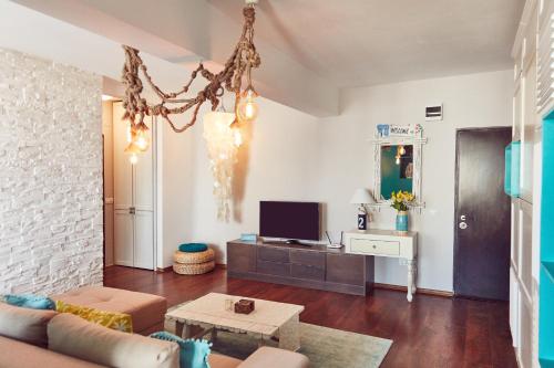 een woonkamer met een bank en een tv bij Holidays Casa del Sole Mamaia Nord in Mamaia Nord – Năvodari
