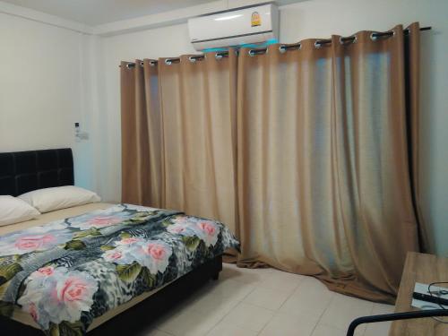 a bedroom with a bed and curtains in it at NB House in Karon Beach