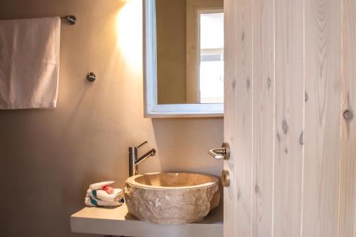 a bathroom with a large bowl sink on a counter at Camara Homes in Andros