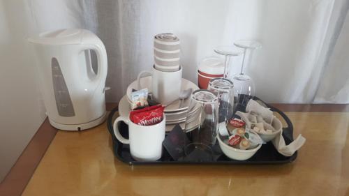 a tray filled with cups and dishes on a table at Haya Guest House in Birmingham