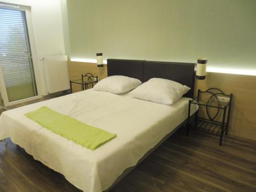 Un dormitorio con una cama con una manta verde. en Azur Apartman en Velence
