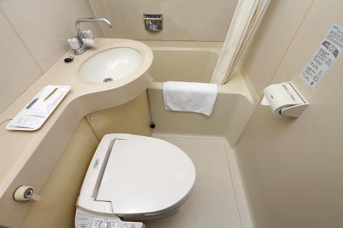 a small bathroom with a toilet and a sink at Kumegawa Wing Hotel in Higashi-murayama
