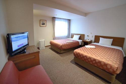 Postel nebo postele na pokoji v ubytování Kumegawa Wing Hotel