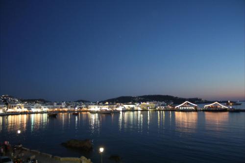 a large body of water with a city at night at Starlight Luxury Studios in Mýkonos City