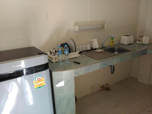 a small kitchen with a sink and a refrigerator at NB House in Karon Beach