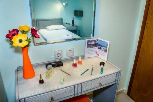 a dressing table with a vase of flowers and a mirror at Louladakis Apartments in Kolymvari