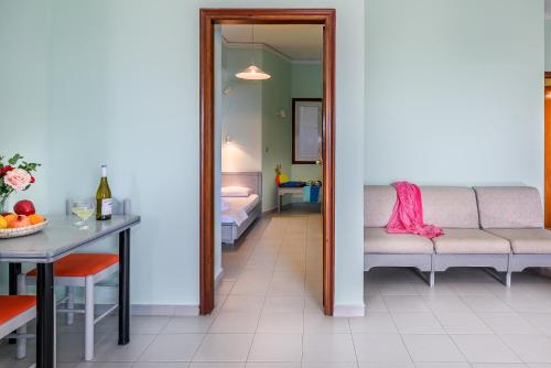 a room with a couch and a table and a bedroom at Louladakis Apartments in Kolymvari