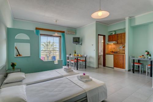 a bedroom with a large bed and a kitchen at Louladakis Apartments in Kolymvari