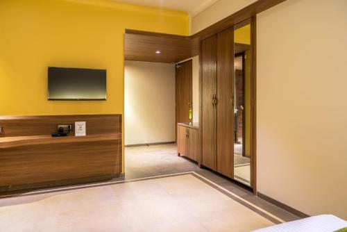 a hotel room with a television on the wall at Treebo Olive Nest in Mumbai