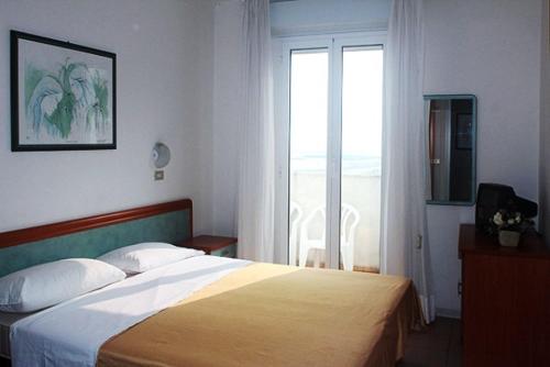 a bedroom with a bed and a large window at Hotel Bellavista-Olympic in Bellaria-Igea Marina