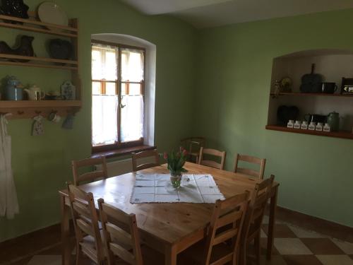 a dining room with a wooden table and chairs at Rekreační dům u Marušky in Božanov