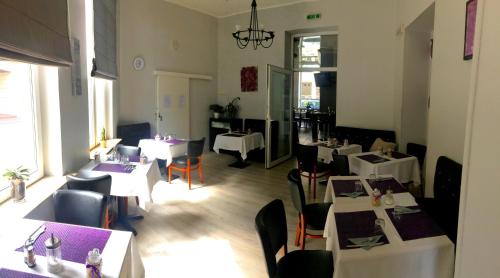a restaurant with white tables and chairs and a room with tables at Hotel-Restaurant Windsor in Mondorf-les-Bains