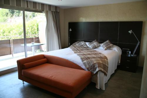 1 dormitorio con cama, sofá y ventana en Montaltmar, en Sant Vicenç de Montalt