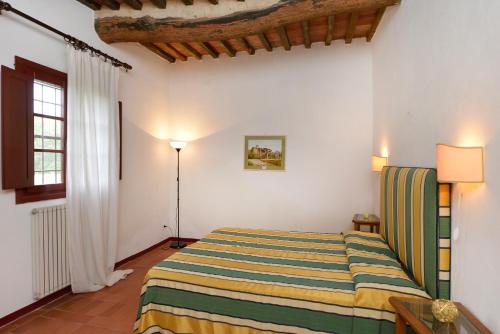 a bedroom with a bed with a striped blanket at Agriturismo Tenuta Vallelunga in Guasticce