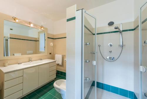 La salle de bains est pourvue d'un lavabo et d'une douche. dans l'établissement Albergo Villa Edy, à Tremezzo
