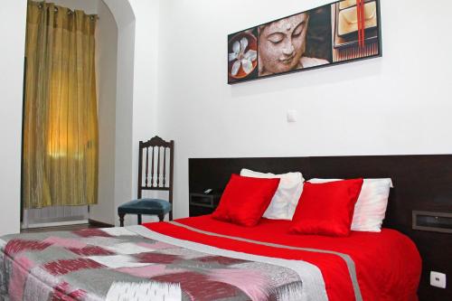 um quarto com uma cama grande e almofadas vermelhas em D. Duarte I em Porto
