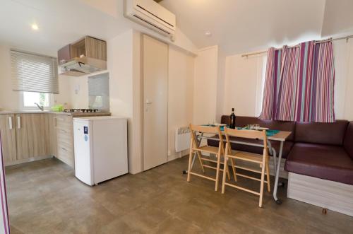 a kitchen with a table and chairs and a refrigerator at Camping Village Torre Pendente in Pisa