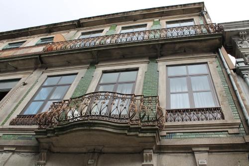 a balcony on the side of a building with windows at Guest House Henrique VIII in Porto