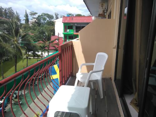 a balcony with two chairs and a view of a park at NB House in Karon Beach