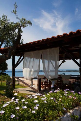 a wooden pergola with a white curtain at 4Elies apartments in Vourvourou