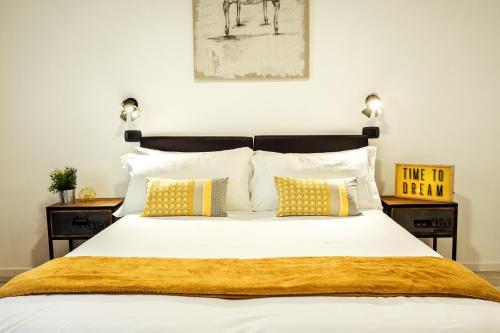 ローマにあるBMGA l Stylish Industrial Termini Apartmentのベッドルーム1室(大型ベッド1台、黄色い枕付)