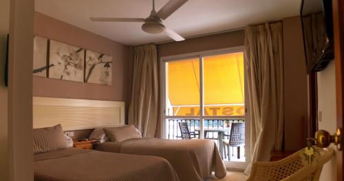 a hotel room with a bed and a television at Hostal Gonzalez in Marbella
