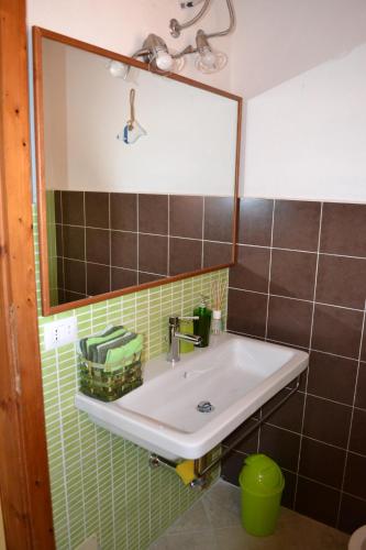 ein Badezimmer mit Waschbecken und Spiegel in der Unterkunft Apartments Mimose in Badesi