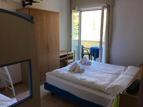 a bedroom with a bed with towels on it at Hotel Vela Azzurra in Malcesine
