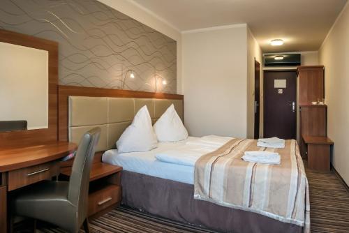 a hotel room with a bed and a desk at Hotel ARA - Dancing Club Restauracja ARA in Jastrzębia Góra