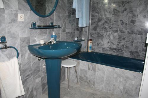 a bathroom with a blue sink and a tub at Apartamento en Familia in Comarruga